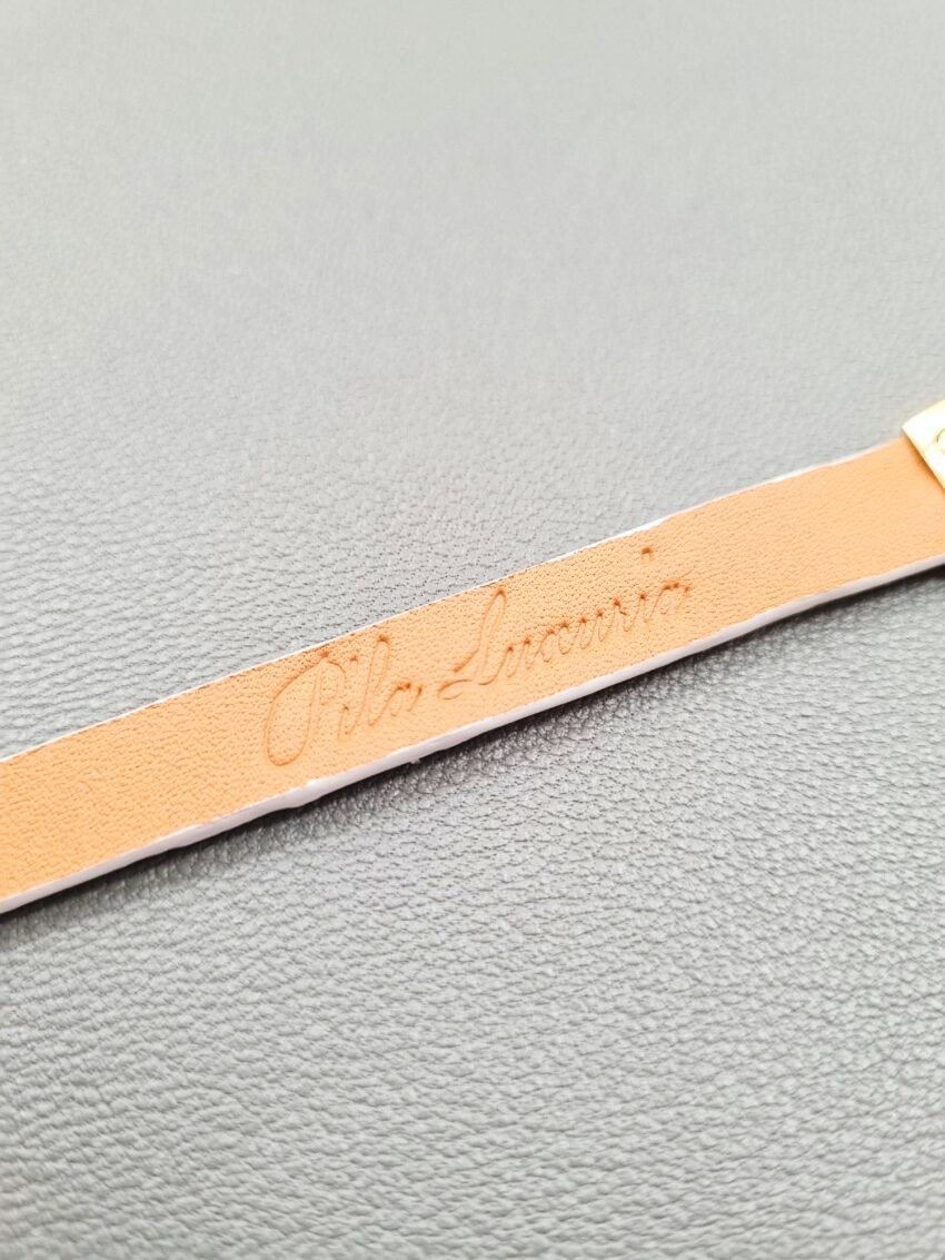 Embossed logo of a luxury white crocodile leather bracelet with a magnetic clasp, made by Pila Luxuria in Canada.