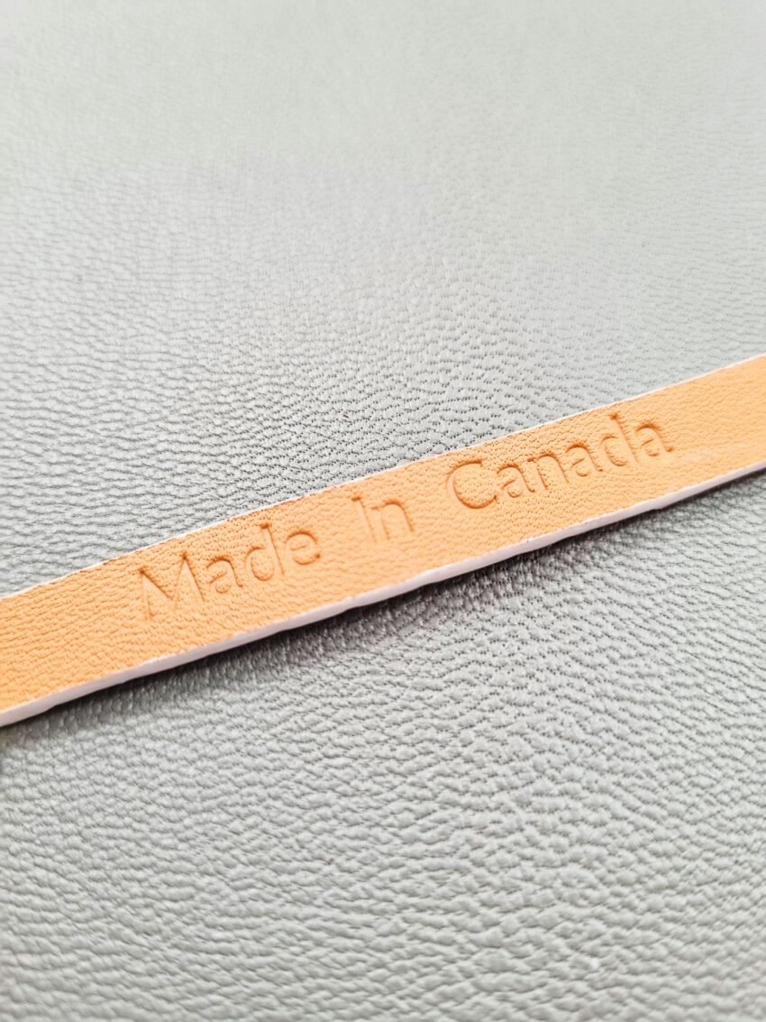 Embossed Made in Canada logo of a luxury white crocodile leather bracelet with a magnetic clasp, made by Pila Luxuria in Canada.