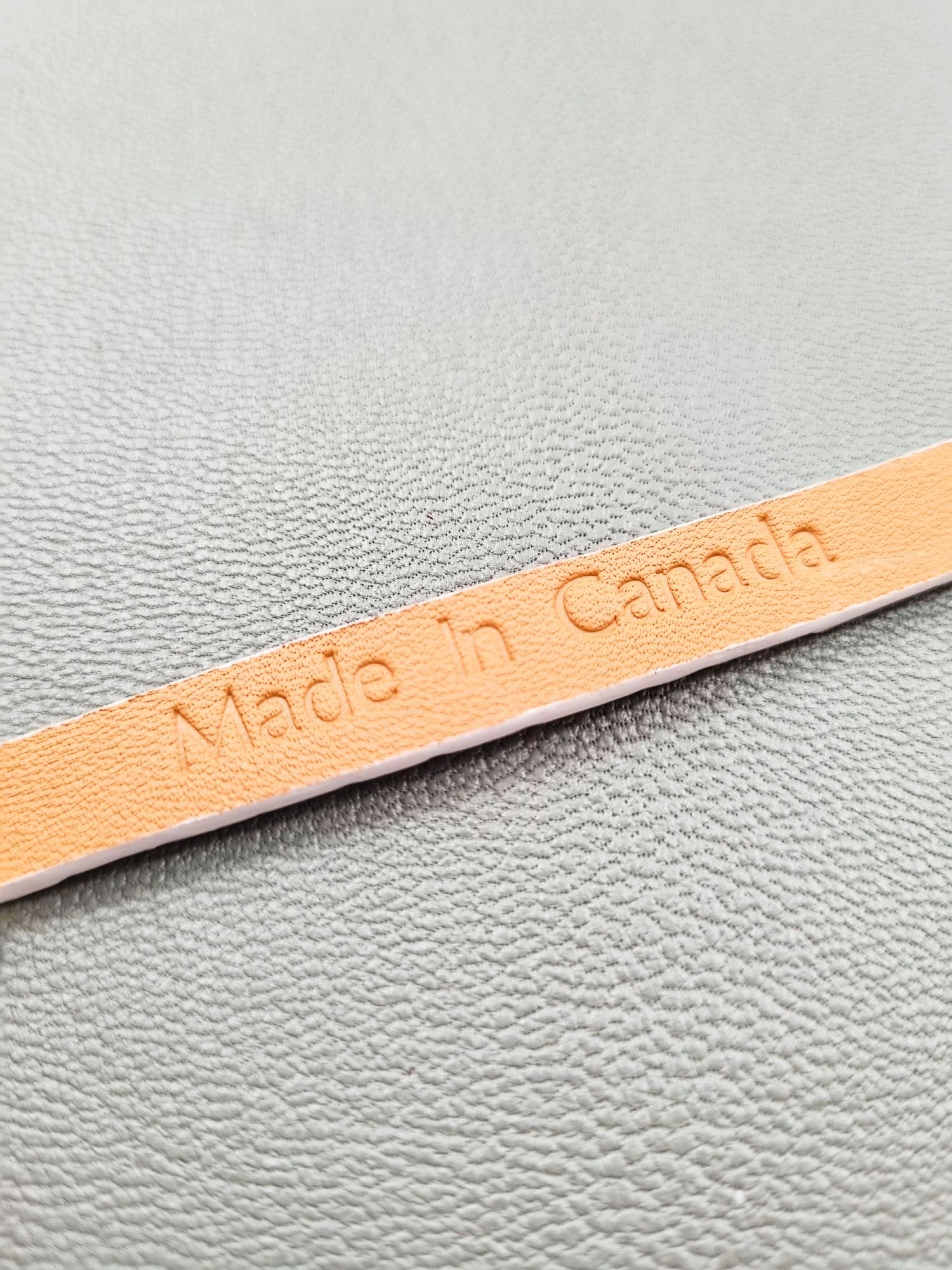 Embossed Made in Canada logo of a luxury white crocodile leather bracelet with a magnetic clasp, made by Pila Luxuria in Canada.